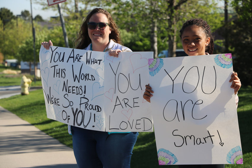 Krystal Jensen, left, and her 12-year-old daughter Kierra welcome STEM students back to school on May 15. About a week earlier, the school experienced a shooting that left one student dead and eigth others injured. "They need all the love they can get right now," said Krystal, who homeschools her daughter.